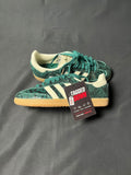 Green Adidas sneakers with a visible tag on a gray background